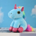 Dettaglio di un unicorno di peluche con criniera arcobaleno e occhi dorati glitterati - Blu