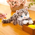 Gatto di peluche realistico tigrato grigio con occhi blu in posa giocosa su legno - Grigio a Righe