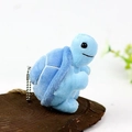 Nahaufnahme hellblauer Plüsch-Schildkröten-Anhänger mit Silberkette auf Holzpodest - Blaue Schildkröte Stil / Blau