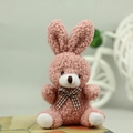 Close-up of pink curly plush bunny toy with a classic plaid bow tie and lamb wool texture - Pink / 10cm
