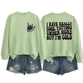 Detail view showing front logo and back slogan of light green long sleeve sweatshirt - S / Tops / Olive Green (Black Print)