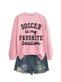 Detail eines rosa Fußball-Sweatshirts kombiniert mit Distressed-Denim-Shorts - S / Rosa