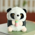 Dettaglio del peluche panda con biberon rosa appoggiato su un libro verde - Rosa (Biberon)