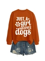 Close-up of orange sweatshirt with JUST A GIRL WHO LOVES DOGS print and ripped denim shorts - Burnt Orange (White Font)