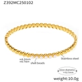Dettaglio del bracciale rigido in acciaio dorato con perle di conchiglia e texture lucida - Stile Perla / Oro
