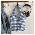 Detail of blue and white gingham tote bag featuring symmetrical front pockets on a wooden rack - Blue