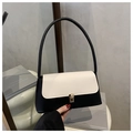 Primer plano detallado de un bolso de hombro bicolor en blanco y negro con cierre dorado - Negro