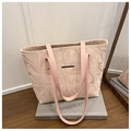 Détail du sac cabas à motif marbre avec anses roses et ornements dorés sur des livres - Rose