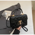 Detail of black quilted texture on handbag with premium gold metal hardware and clasp - Black