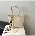 Chic beige bucket bag with lychee texture and beaded pendant detail on a white box - White with Pendant