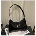Detalle del bolso de hombro en charol negro brillante con hebilla de lazo metálico dorado - Negro