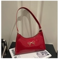 Detalle de bolso de hombro en charol rojo con lazo de metal dorado y cremallera - Rojo