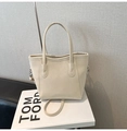 Detailed view of cream leather bucket bag with logo print on white decorative books - White Without Pendant