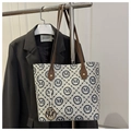 Close-up of beige tote bag with blue M patterns, brown leather strap, and gold metal charm - Gray