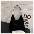 Detail shot of black faux fur shoulder bag featuring soft texture and sleek leather strap - Black