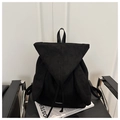 Détail du sac à dos en daim noir avec oreilles de lapin posé sur un fauteuil en cuir noir - Noir