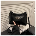 Detail of black patent leather shoulder bag with gold bow clasp and shoulder strap - Black