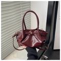 Detail der burgunderroten Beuteltasche mit Falten-Design und goldenen Metallelementen - Rot