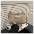 Detailed shot of beige glossy shoulder bag featuring an elegant gold bow hardware detail - Khaki