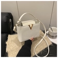 Détail du sac seau blanc en cuir avec boucle en V dorée et bandoulière réglable pratique - Blanc