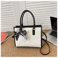 Detailed view of color-block tote bag with snake pattern and decorative silk scarf accent - Black
