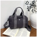 Dettaglio borsa Boston in tela lavata con logo M FASHION su tavolo in legno scuro - Viola