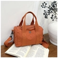 Dettaglio della borsa Boston in nylon arancione con logo in metallo e manici in tessuto - Arancione