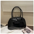 Detail of black glossy tote bag featuring a decorative bow and twin long shoulder straps - Black