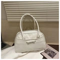 Detail of cream white leather tote bag with a leather bow and gold brand lettering - White
