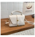Close-up of cream pebble leather texture and gold circular buckle on a crossbody bag - Litchi Pattern Square Bag (25069) / White