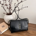 Retro black leather shoulder bag with gold metal buckle on a rustic wooden desk - Black