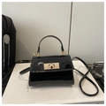 Détail de la surface en cuir verni noir brillant et du fermoir doré du mini sac à main - Noir
