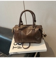 Détail d'un sac Boston marron foncé en cuir grainé avec logo FASHION AIR PARIS gravé - Sans pendentif / Marron