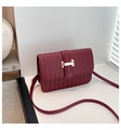 Close-up of dark red woven leather crossbody bag with gold H-buckle on a white surface - Red