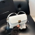 Sac à main minimaliste en cuir blanc avec fermoir doré sur fond de cuir noir - Blanc