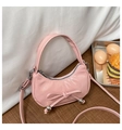 Detail der rosa Hobo-Tasche mit Schleifendekoration und Metallperle auf Holzfläche - Rosa