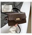 Detail einer dunkelbraunen gewebten Handtasche mit goldenem Drehverschluss und Tragegriff - Braun