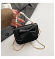 Dettaglio di mini borsa nera con grande fiocco 3D e manico elegante in perle - Nero