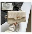 Detail der cremefarbenen geflochtenen Handtasche mit goldenem Drehverschluss - Weiß