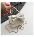 Dettaglio della mini borsa con manico di perle, fiocco grande e tracolla a catena oro - Bianco