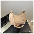Primer plano detallado del bolso de media luna en cuero beige con asas anudadas y herrajes oro - Caqui
