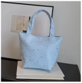 Close-up of light blue star sequin tote bag on book showing starry pattern and texture - Blue Without Charm