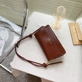 Brown leather baguette bag with a gold logo and adjustable strap in a minimalist style - Dark Brown
