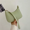 Close-up of pistachio green crescent shoulder bag with lychee grain texture and metal zipper - Green