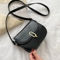 Borsa a sella nera chic con fibbia dorata e tracolla sottile tenuta in mano con eleganza - Nero