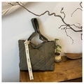 Close-up of army green quilted tote bag with diamond stitching and EARE letter strap - Green