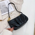 Black pleated baguette bag with gold chain strap detail on minimalist background - Black