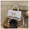 Detail of light blue pleated handbag with pearl handle and silver bow decoration - Blue
