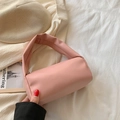 Minimalist soft pink cylinder handbag with wide handle on white fabric background - Pink