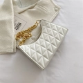 White quilted shoulder bag with chunky gold chain strap on artistic white background - White